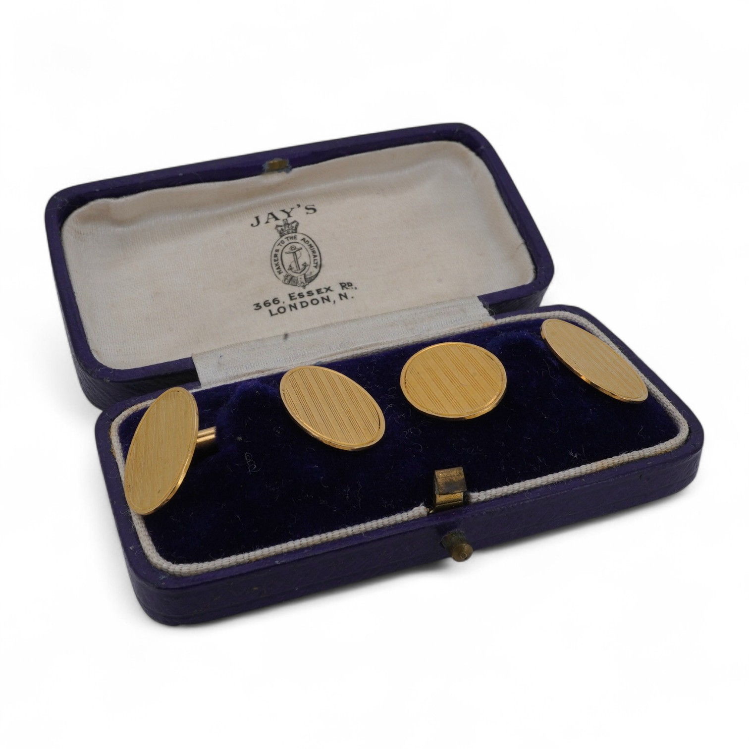 A pair of gold cuff-links, each end of oval outline with striped engraving, to a bar connector, each end 1.8cm, each stamped 18ct, combined gross weight approximately 9.5 grams, maker's marks EH, case stamped Jay's, Cond